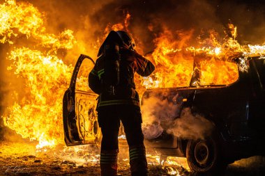 A beautiful shot of a fire man Extinguish the fire from a burning car