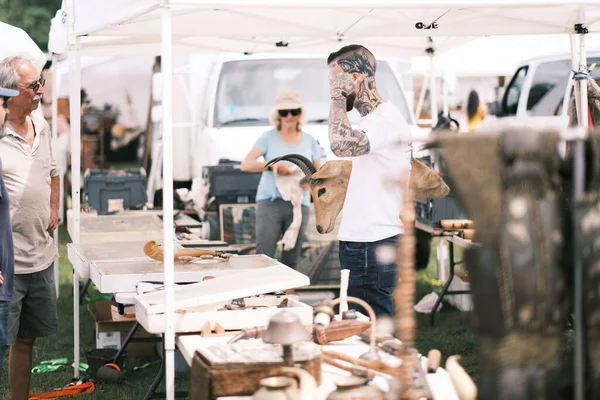 A closeup of a man holding a deer head decor in his arm