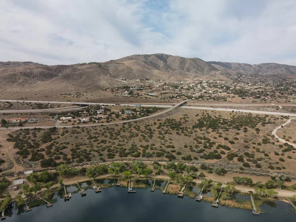 An aerial view of docks at lake Palmdale and the 14 freeway in the background with mountains