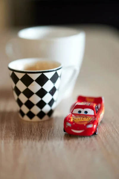 Vertical Shallow Focus Lightning Mcqueen Toy Car Next Cups Coffee — Stockfoto