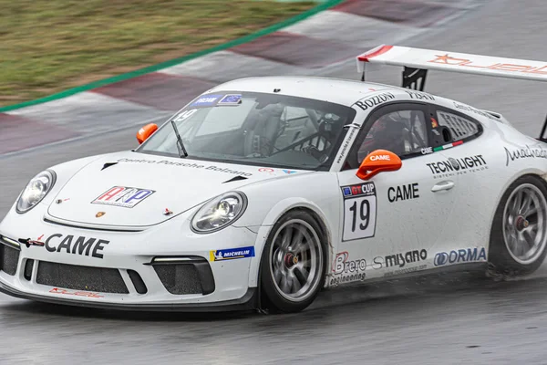 Islak pistte yarış arabası, yağmurlu bir günde. Porsche 911 Kupa 2018