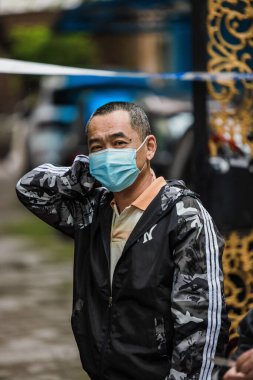 Çin, Şangay 'daki Coivd169 tecridi sırasında kameraya bakan maskeli bir Çinli.
