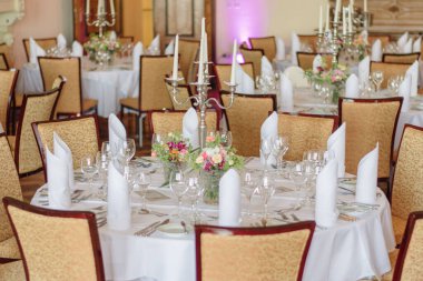 Düzenlenmiş yemek masaları olan bir düğün yeri.