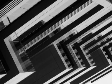 A grayscale shot of an abstract modern geometric building with sharp-edged balconies