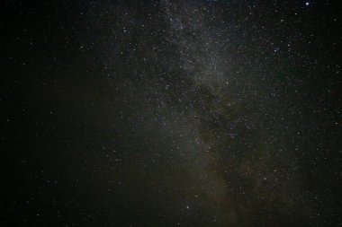 Gece gökyüzünde parlayan yıldızlarla Samanyolu 'nun manzarası.