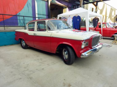 Old red and white sporty Studebaker Lark four door sedan 1959. Expo Fierro 2022 classic car show. Copyspace