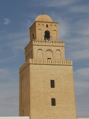 A beautiful vertical view of an old mosque against blue sky in Tunisia, Africa
