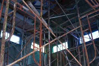 Bitmemiş ev projesinde paslı eski bir yapı iskelesi.