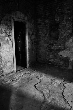 Terk edilmiş psikiyatri bölümü binasının iç kısmının dikey gri tonlu görüntüsü.