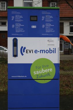 30 Ocak 2022, Bad Salzdetfurth, Lower Saxony, Almanya, White and Blue EVI elektrikli araçlar için sağdaki turuncu eklentili şarj istasyonu