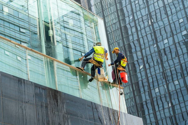 Chongqing, Çin-20 Temmuz 2021: Yüksek katlı dış binanın pencerelerini temizleyen Çinli işçi.