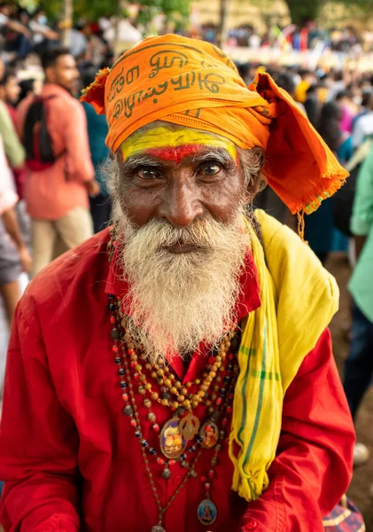 A vertical shot of elderly Indian man in Indian traditional clothing looking at camera