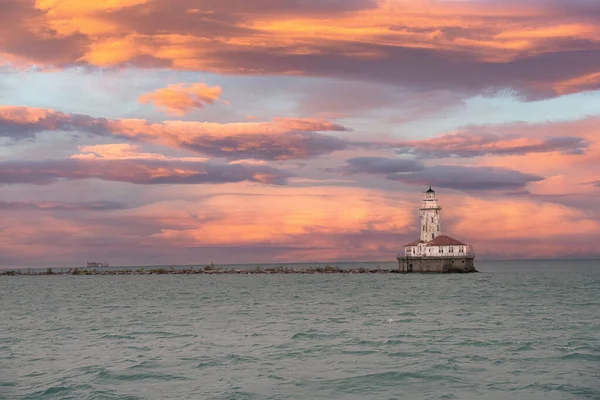 A scenic cloudy sunset at a coast with a lighthouse