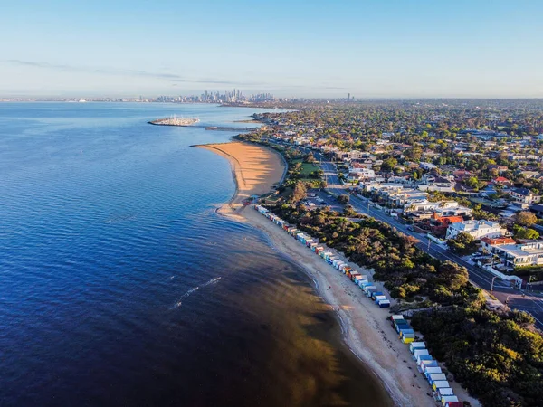 Brighton beach boxes and Melbourne skyline at sunrise