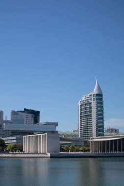 A vertical shot of Sao Gabriel Towers against the blue sky with calm lake on the foreground
