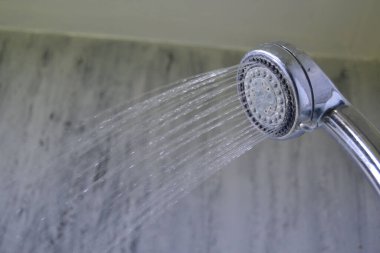 A closeup of a shower splashing water in a bathroom