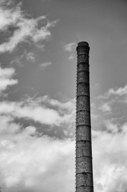 A high old chimney made of bricks and a sky