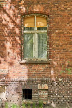 A damaged window and old wall on a sunny day