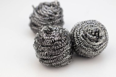 A closeup of three steel wool scourers isolated on white