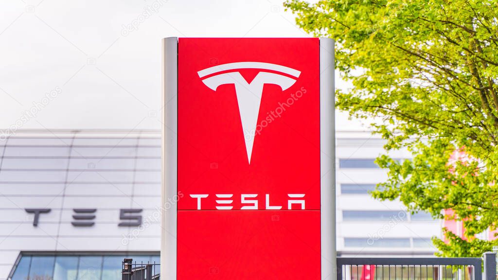 Tesla logo at the Tesla service center with a visible hall behind it