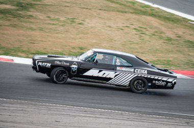 Dodge Charger yarış pistinde sürükleniyor.