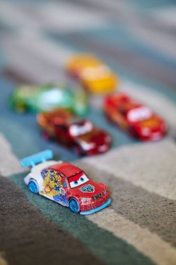 A vertical selective focus shot of Ice Racer toy car from the Disney Pixar Cars movie on a carpet