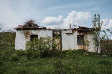 A daylight shot of an old abandoned building in the field