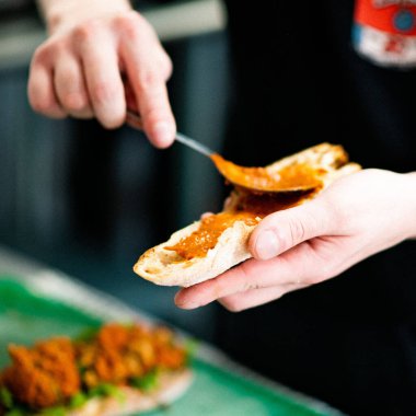 Vejetaryen sandviçe sos eklerken çekilmiş yakın plan bir fotoğraf.