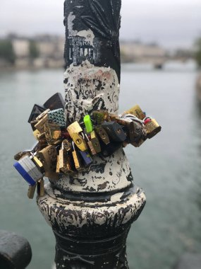 Paris, Fransa 'da metalik bir direkte asılı duran kilitlerin dikey yakın çekimi