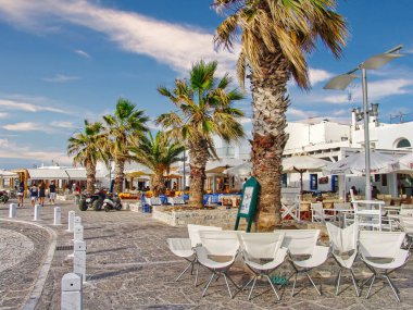 A beautiful view of palm trees line, village of Naousa on Paros island, Greece with a blue cloudy sky