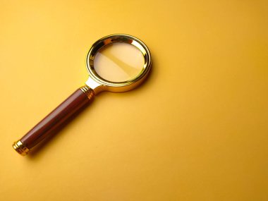 Sarı arkaplanda izole edilmiş kaliteli pirinç renkli bir büyüteç..