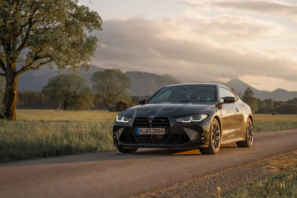 Günbatımında modern bir BMW M4 'ün, Dağ v. lüks spor arabalı görüntüsü birçok sürücünün hayalindeki arabadır.