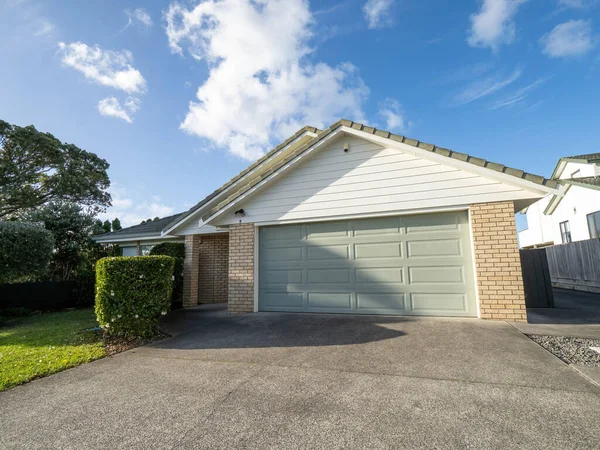 View of suburban garage with roller door under gabled roof