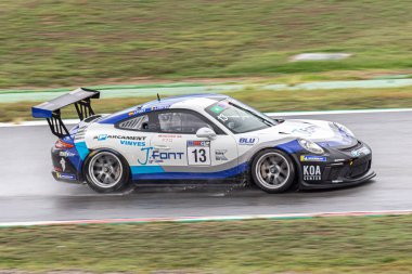 Islak pistte yarış arabası, yağmurlu bir günde. Porsche 911 Kupa 2018