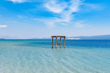 Güneşli bir yaz gününde denizde boş bir salıncak.