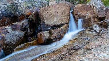 John Muir Trail, California, ABD 'de kayaların üzerinden güzel bir nehir manzarası akıyor.
