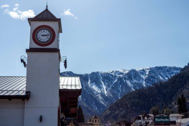 A clock tower in Leavenworth, Washington with mountains in the background