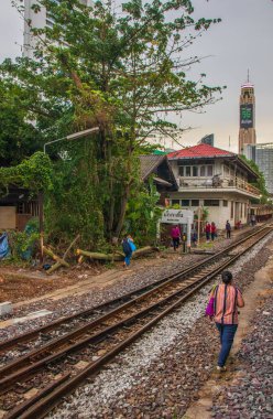 Tayland 'ın güneydoğusundaki Bangkok banliyösündeki bir tren istasyonunun raylarındaki Taylandlılar