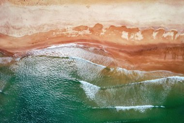 The bird's eye view of the sandy shore and greenish sea. Guangdong, China.