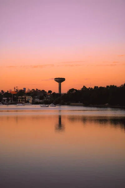 夕暮れ時には水面に映る湖によって 塔や木々のある街の美しい景色 — ストック写真