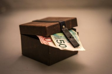 Deri sandıkta İsrail Shekel banknotlarının yakın plan çekimi.