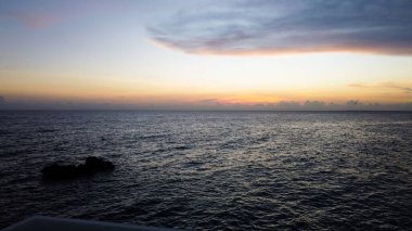 Gökyüzünün arka planında gün batımına boyanmış güzel bir deniz.