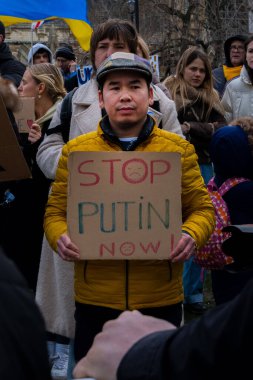 Ukrayna 'daki savaşı sona erdirme protestosu sırasında kalabalığın içinde duran bir adam.