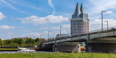 Louis Raemaekers köprüsü diğer bir deyişle De Maasbrug 'un altında bir yat ve arkada Natalini Kulesi, Roermond, Hollanda