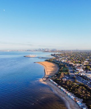 Brighton beach boxes and Melbourne skyline at sunrise