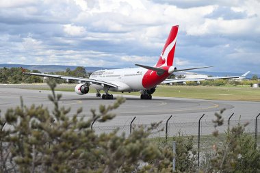 Bulutlu gökyüzünün arka planında Qantas uçağının görüntüsü