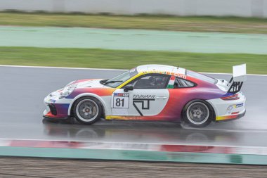 Islak pistte yarış arabası, yağmurlu bir günde. Porsche 911 Kupa 2018