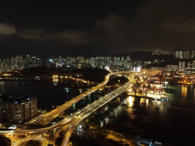 Hong Kong 'da gece aydınlatmalı yoğun kıyı şeridi binalarının havadan çekilmiş görüntüleri.