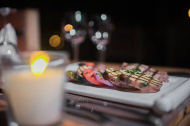 Kızarmış patates, domates ve soğanlı bir tabak et.