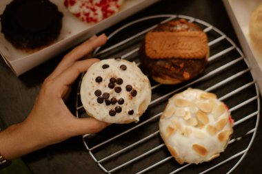 A top view of a hand selective a homemade creamy pastry